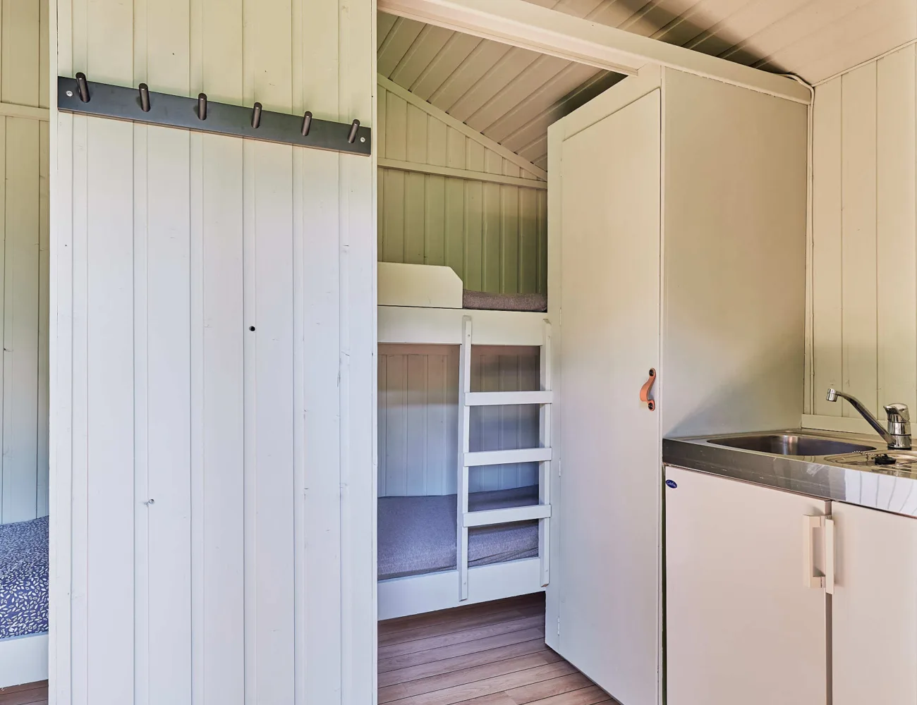 Bilde som viser køysenger bak skillevegg i campinghyttene på Tjugen camping7